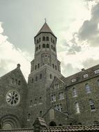 Beautiful, old church with the tower, under the sky with clouds and light