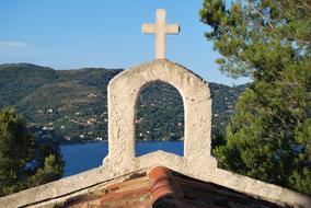 arch with a cross on the roof of a church near the sea