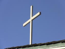 white cross on the roof against the blue sky
