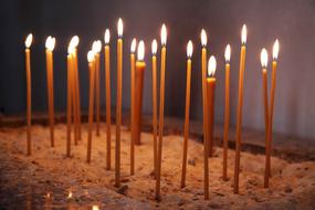 Bright Candles on the sand in the church close-up