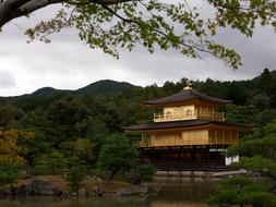 Beautiful temple, near the water, among the colorful trees, in Japan, under the cloudy sky