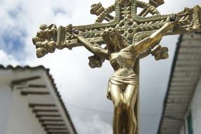 golden crucifix outdoors on blurred background