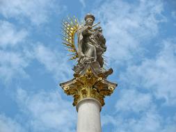 statue of the madonna and child on a golden column