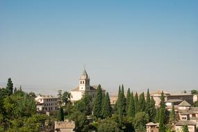 Beautiful village with the church, among the green trees, near Granada, Spain