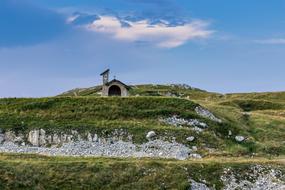 Beautiful landscape of the church, on the green mountains at blue sky with white clouds on background, Italy