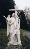 stone sculpture of a white angel with a cross