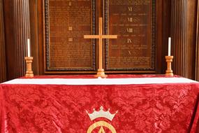 candles and a cross on the red altar