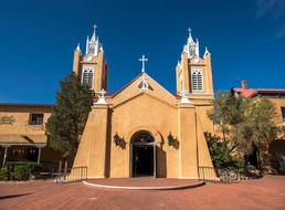 photo of a yellow stone church against a blue sky