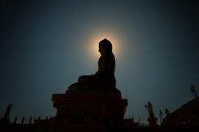 Statue Buddha against the backdrop of the bright sun