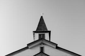 Black and white photo of the beautiful church, with the steeple, with the cross