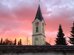 Beautiful church with the steeple, among the trees, at colorful and beautiful sunrise