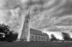 old Church with spire beneath clouds, black and white