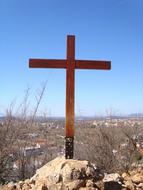 wooden cross on a stone mountain on a sunny day