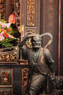 Statue and colorful and beautiful flowers near the architecture, in the temple