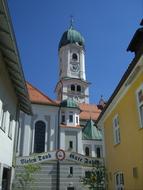 Beautiful and colorful church among the other buildings, in Nesselwang, Germany, in sunlight, under the blue sky