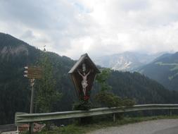 cross near the road in the alps