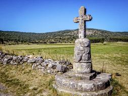 stone cross on the colorful and beautiful path on the hills
