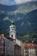 church building among city houses with mountains in the background