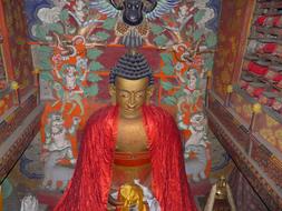 Beautiful and colorful statue of Buddha near the painting