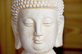 Portrait of the beautiful, white Buddha statue, at blurred background