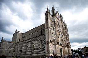 a crowd of people near the church in cloudy weather