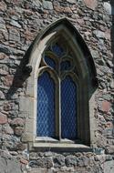 window on the facade of a stone church close up