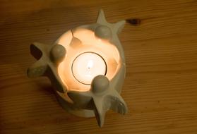 Beautiful, burning candle with the angels, on the wooden surface