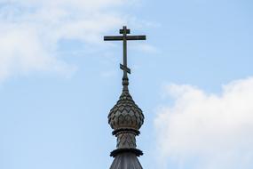 cross on the dome against the sky with clouds