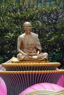 golden monk statue on a sunny day