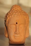 Beautiful, smiling Buddha statue with the cute ladybug, at sunset