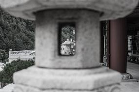 Black and white photo with close-up of the stone sculpture, near the plants