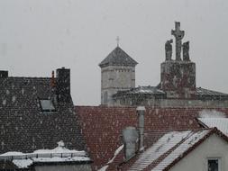 snowflakes fly over houses in winter