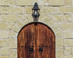 street lamp on the wall above the wooden door