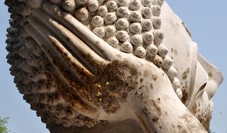 Beautiful statue of Buddha, with hand, in sunlight, in Ayutthaya, Thailand, under the blue sky