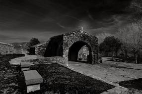 Black and white photo of the beautiful church in Ussassai, Sardinia, Italy, among the trees