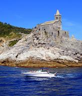 Boat speeding on water near Castle on Cliff, italy, liguria, porto venere