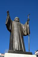 the statue of the priest against the blue sky