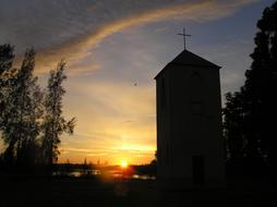 Beautiful landscape with silhouette of the church with cross, among the plants, in Castlereagh, at colorful and beautiful sunrise