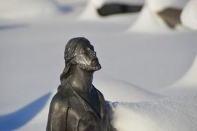 figure of Jesus Christ in the snow at the cemetery