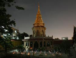 Beautiful and colorful Pagoda near the building with lights, in Thailand, in the evening