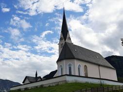 Beautiful landscape with the church on the mountains, in Kreuth, Bavaria, Germany, under the blue sky with clouds