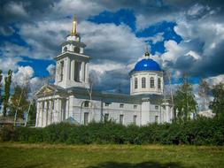 Beautiful and colorful church among the colorful plants in Russia under the blue sky with clouds