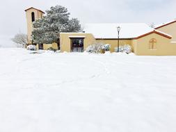 Beautiful, snowy landscape with the church, among the trees, in the winter