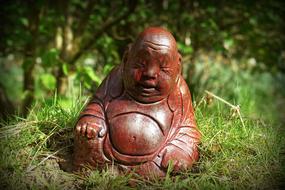 Buddha Statue in the grass close-up on a blurred background