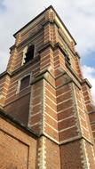 Beautiful and colorful church tower under the blue sky with clouds, in Merksem, Antwerp, Belgium