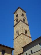 church tower against blue sky in volterra, Italy