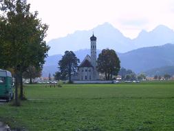 green field, mountains, church