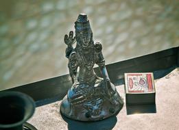 metal figurine of shiva and a box of matches