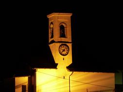 illuminated church with a spire at night