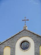 cross on the roof of the church against the blue sky